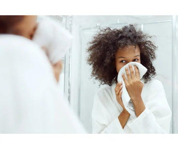 stock photo of a black woman drying her face with a towel