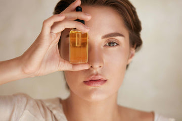 Stock photo of a woman holding a face oil 